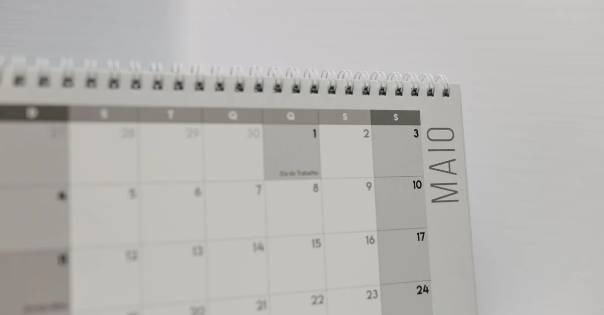 Calendario encuadernado en espiral que muestra el mes de mayo, con especial atención a los días de la semana en portugués.