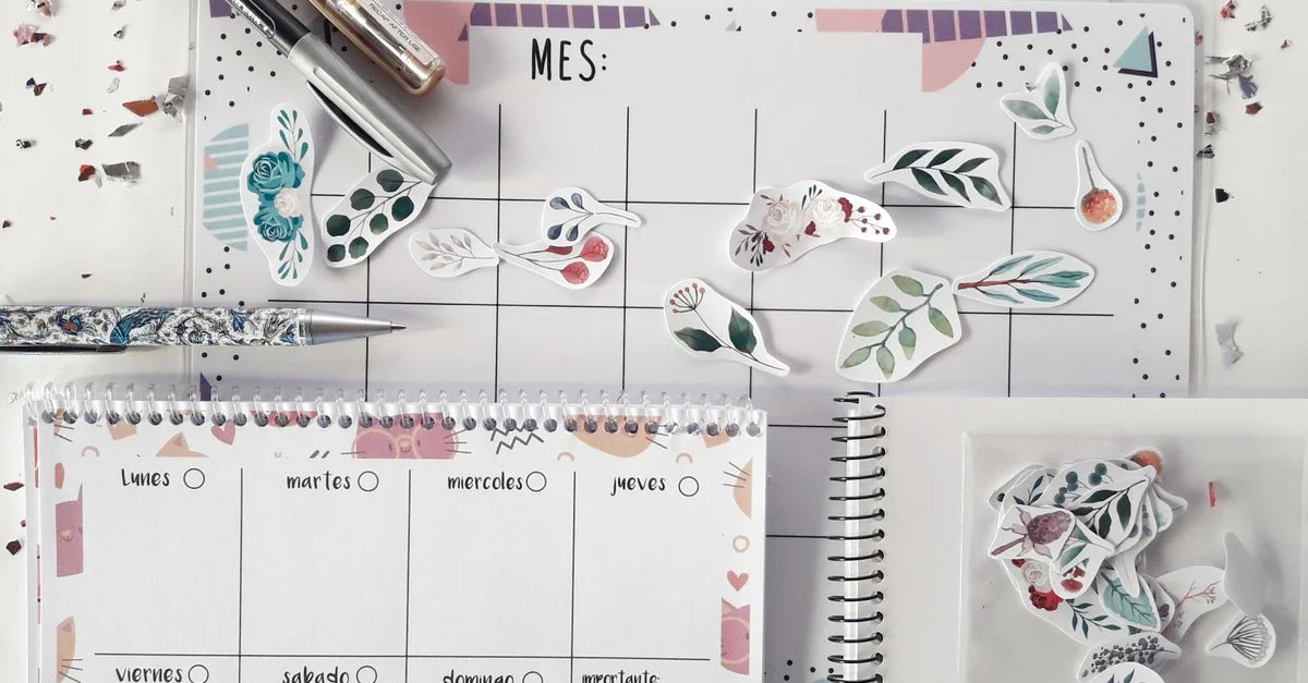 Plano plano de un planificador con pegatinas decorativas y papelería para organizar tareas de forma creativa.