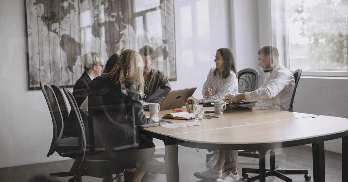 Un grupo diverso de colegas en una reunión en un entorno de oficina moderno.
