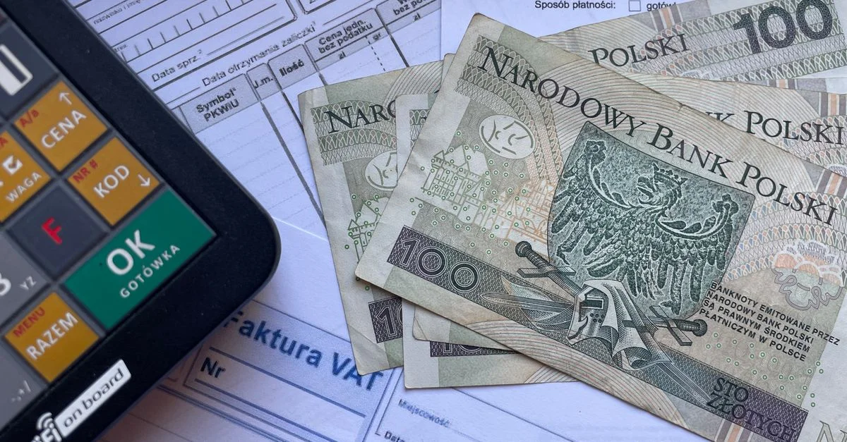 Moneda polaca colocada en facturas con una calculadora, ilustrando transacciones financieras o presupuestos.